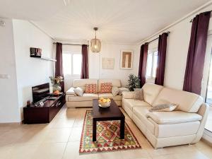 a living room with a couch and a table at Elegant apartment with stunning pool views at La Torre Golf- MO2412LT in Torre-Pacheco