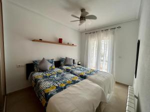 a bedroom with a bed and a ceiling fan at Elegant apartment with stunning pool views at La Torre Golf- MO2412LT in Torre-Pacheco +28 photos