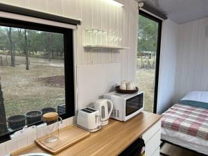 cocina con microondas en una encimera con ventana en 5 Acre Retreat, en Jimboomba
