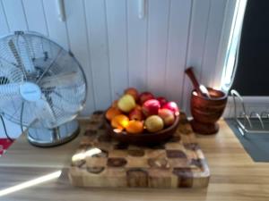 un bol de fruta en una mesa junto a un ventilador en 5 Acre Retreat en Jimboomba