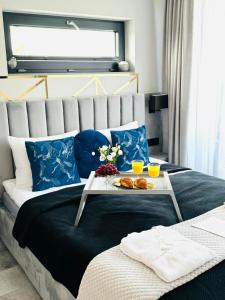a bed with a tray of food on top of it at Apartamenty Blue Baltic Chłopy nad morzem in Chłopy