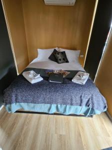 a bed with two pillows and a book on it at Alma Tiny House in Willunga