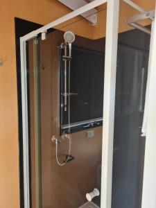 a shower in a bathroom with a glass door at Alma Tiny House in Willunga