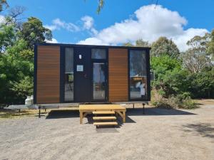 a tiny house with a wooden table and a bench at Alma Tiny House in Willunga