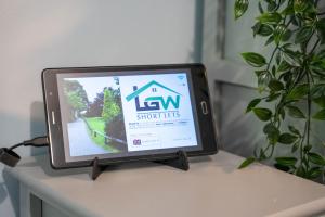 a tv on a table with a sign on it at Park View- 2 bed apartment close to East Surrey Hospital in Salfords