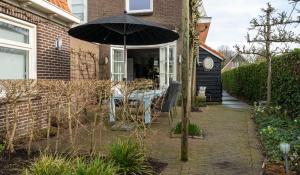 a patio with a table and an umbrella at ootmen in Wolphaartsdijk