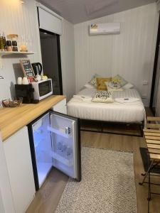 Kleines Zimmer mit einem Bett und einer Mikrowelle. in der Unterkunft Tiny House Elevation 156-2 in Amamoor