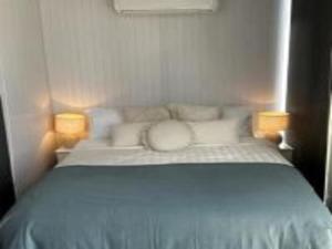 ein Schlafzimmer mit einem Bett mit zwei Leuchten in der Unterkunft Toowoomba Valley Views in Gowrie Little Plain
