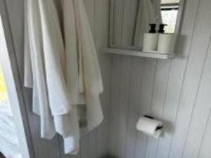 a bathroom with white towels and a roll of toilet paper at Toowoomba Valley Views in Gowrie Little Plain