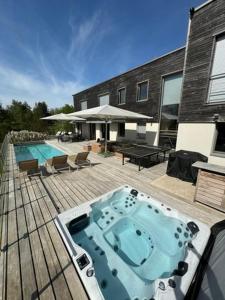 einem Whirlpool auf einer Terrasse neben einem Gebäude in der Unterkunft Villa d'exception M54 Vouvray à 2H au sud de Paris proche Amboise Chenonceau Chambord in Vouvray