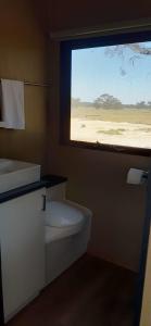 a bathroom with a window with a toilet and a sink at Willalooka Escape in Willalooka 