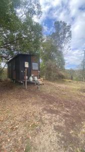 a tiny house sitting in the middle of a field at Hill Creek 3 Tiny House in Perwillowen
