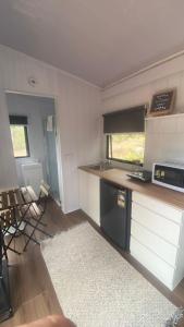 a kitchen with a stove and a counter with chairs at Hill Creek 3 Tiny House in Perwillowen