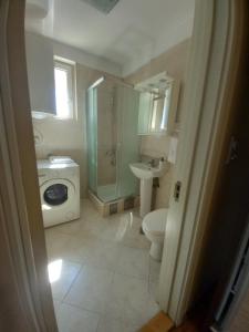 een badkamer met een douche, een toilet en een wastafel bij TWINS in Belgrado