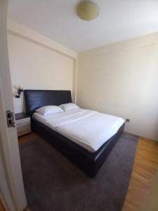 een slaapkamer met een groot bed met witte lakens bij TWINS in Belgrado