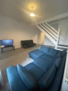 a living room with a blue couch and a tv at The Castle - Grimsby/Cleethorpes perfect for Contractors in Grimsby