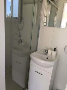 een witte badkamer met een wastafel en een douche bij Red Gum at Aranya Acres in Bungendore