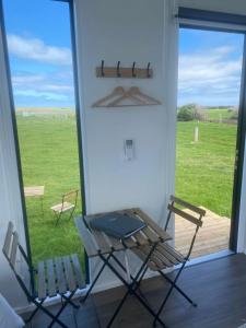 tavolo e sedie in una stanza con finestra di Lough View Cabin a Rosecrook