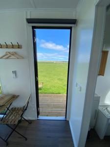 a door leading to a patio with a view of a field at Lough View Cabin in Rosebrook