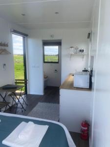 a white kitchen with a counter and a table at Lough View Cabin in Rosebrook