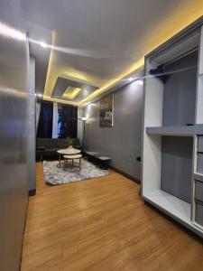 een kamer met een woonkamer met een tafel en een bank bij melfaidy staycation in Imus