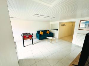 a living room with a blue couch and a table at maison in Cholet