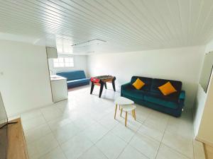 a living room with a couch and a table at maison in Cholet +1 photo
