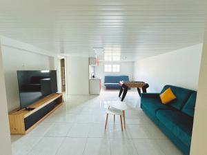 a living room with a blue couch and a table at maison in Cholet