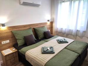 a bedroom with a bed with two towels on it at Balatonkenese Sunshine Villa in Balatonkenese
