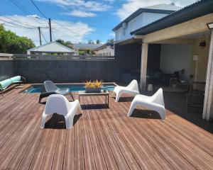 une terrasse avec des chaises, une table et une piscine dans l'établissement La villa Loca Reunion, à Saint-Joseph