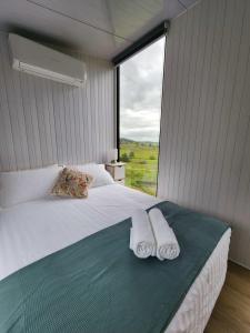 a bedroom with a large bed with two towels on it at Hampson Farm Stay Hill Top in Kyogle