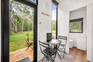 um quarto com uma mesa e cadeiras numa casa em Clarence Farm Stay em Maclean