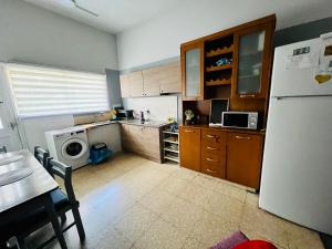 a kitchen with a refrigerator and a table and a microwave at Past or Tail rooms in Larnaka