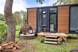 a woman sitting in a tub in a tiny house at Clarence Farm Stay in Maclean