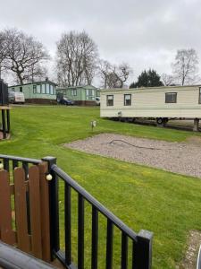 a view of a park with two mobile homes at Caravan SK 110 in Leven