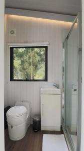 bagno bianco con servizi igienici e finestra di Piyar Tiny Haven a Julatten