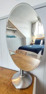 ウィンダミアにあるInvergarry Room Only Guest House For Adultsの円形の鏡(ベッド付)