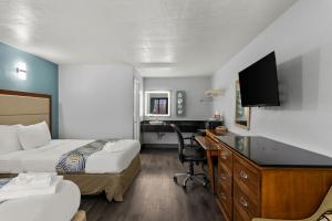 Habitación de hotel con 2 camas y escritorio en Americas Best Value Inn Bangor en Bangor