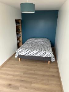 - une chambre avec un lit et un mur bleu dans l'établissement Appart, à Rougemont