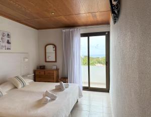a bedroom with two beds and a large window at Hotel Rosamar - Emar Hotels in Es Pujols