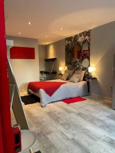 a bedroom with a large bed with a red blanket at Le studio urbain qu’il vous faut ! in Saint-Dizier