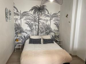 a bedroom with a bed with palm trees on the wall at ღ L'Échappée Belle - Niché au cœur de Montélimar in Montélimar