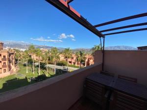 a balcony with a view of a street and palm trees at Albatros Apartamentos Playa Granada in Motril