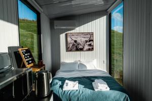 a bedroom with a bed and a large window at Mighty Tiny House 1 in Ruawaro