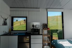 a bedroom with a desk with a television and a bed at Mighty Tiny House 1 in Ruawaro