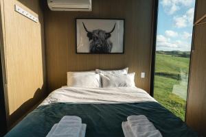 - une chambre dotée d'un lit avec une photo de taureau dans l'établissement Mighty Tiny House 2, à Ruawaro