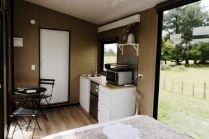 uma pequena cozinha com um lavatório e um micro-ondas em Rural Delight em Ohaupo
