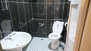 a black tiled bathroom with a toilet and a sink at Simon Hotel in Istanbul +25 photos