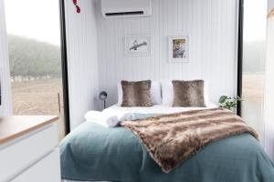 a bedroom with a large bed with a window at Muddy Hill Moments in Arrowtown