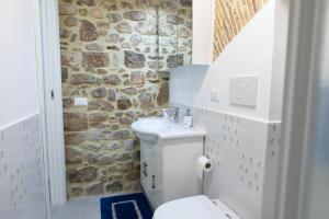 a bathroom with a white toilet and a stone wall at Casa Di Circe Vista Mare - Centralissima, ad un passo da Tutto in Terracina +43 photos